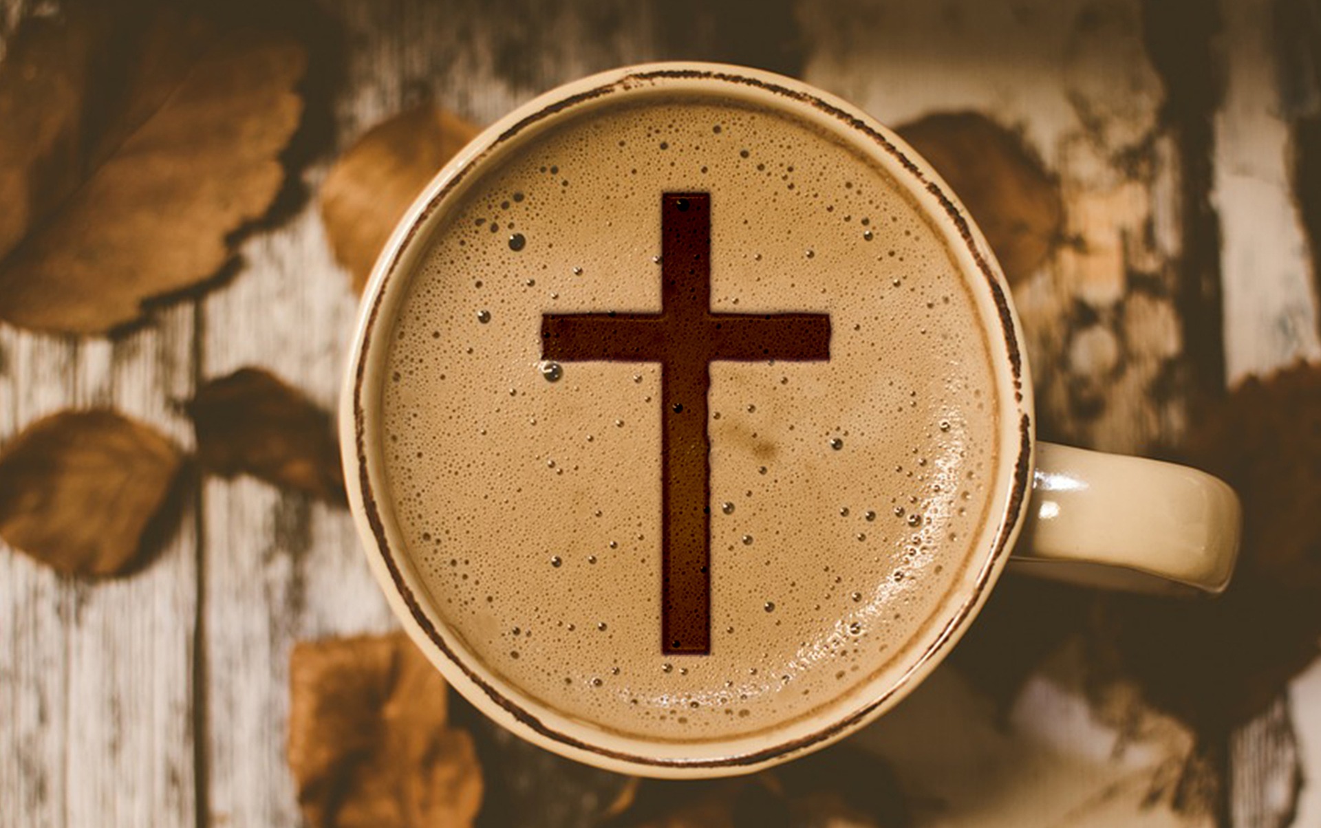 Kahvikuppi kuvattuna ylhäältä päin ja kahvin pintaan muodostuu risti.
